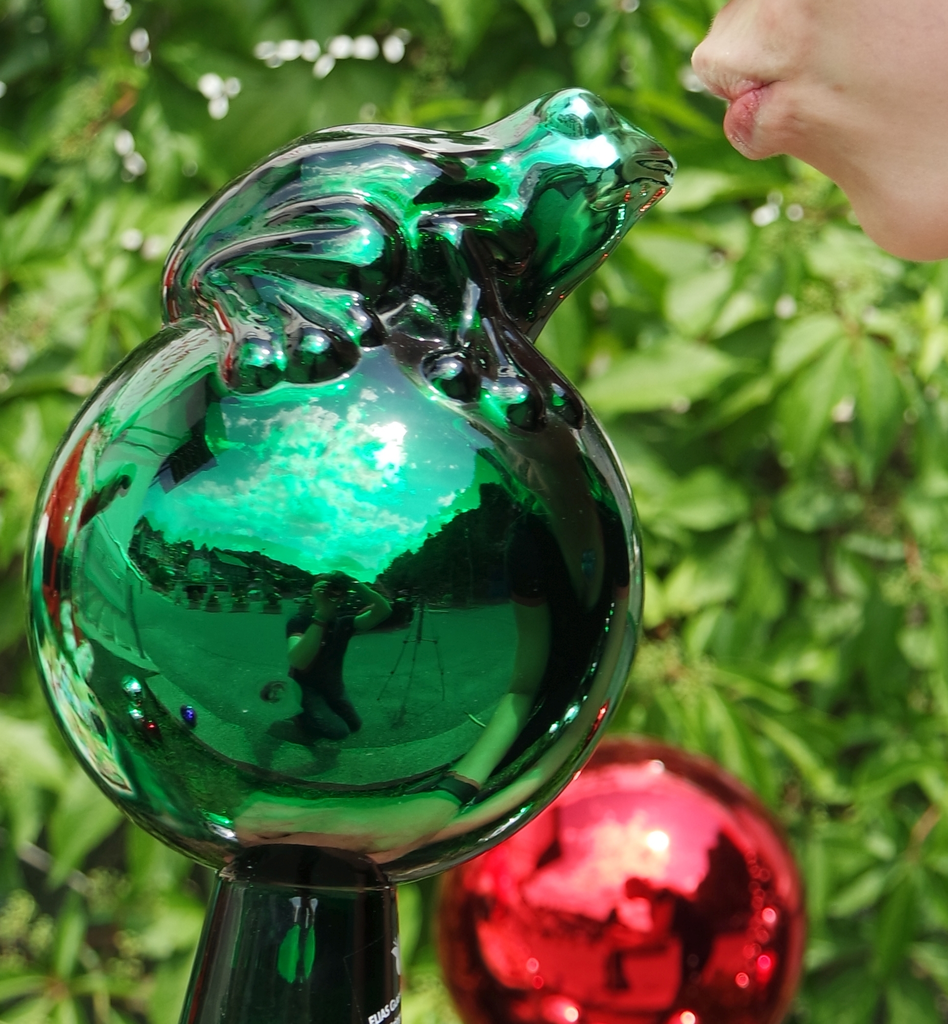 Klassische Rosenkugel aus Glas in einer märchenhaften Gartenlandschaft